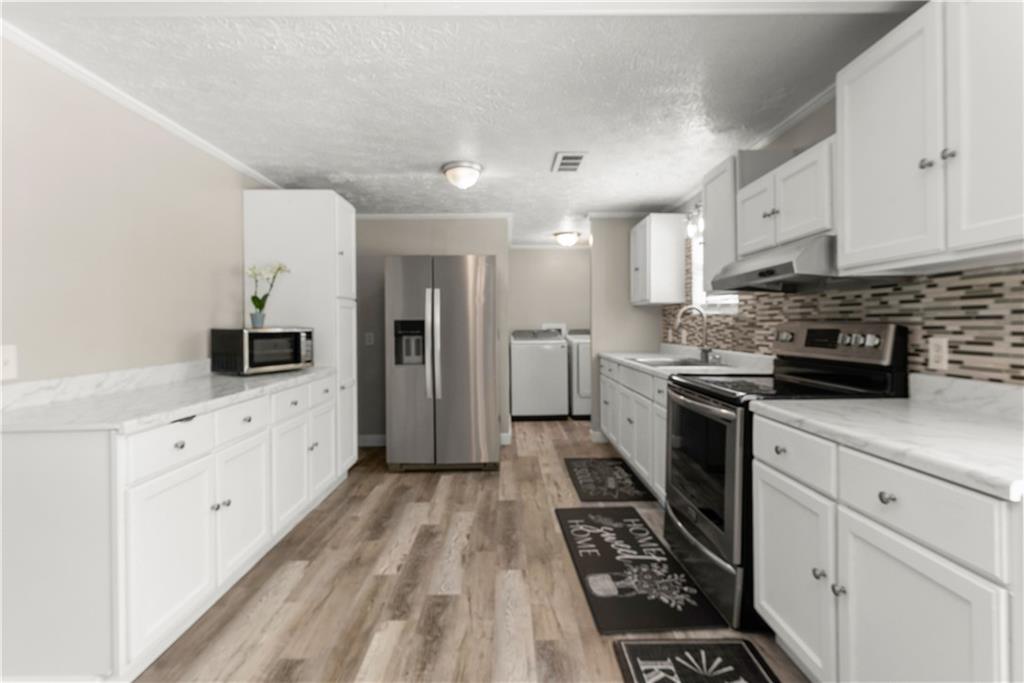 1670 Azelea Lane Gainesville, GA 30507 - Photo 8 of 33 a kitchen with granite countertop a refrigerator stove top oven and sink