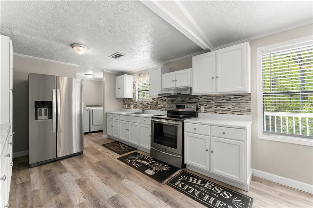 1670 Azelea Lane Gainesville, GA 30507 - Photo 9 of 33 a kitchen with white cabinets and appliances