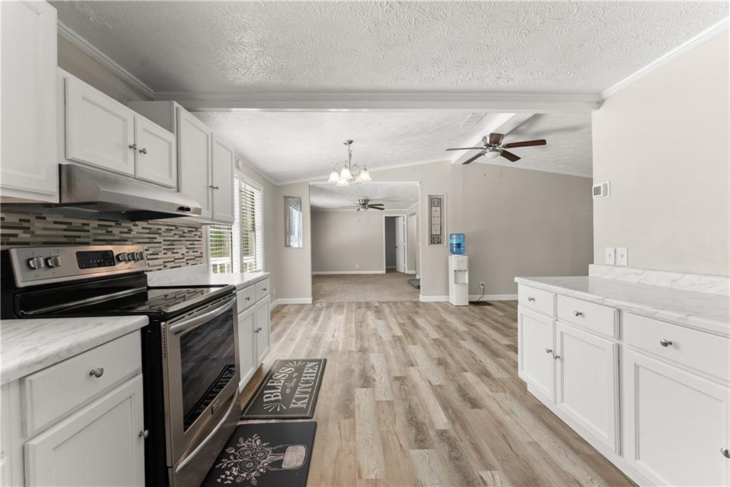 1670 Azelea Lane Gainesville, GA 30507 - Photo 10 of 33 a kitchen with granite countertop a stove cabinets and wooden floor