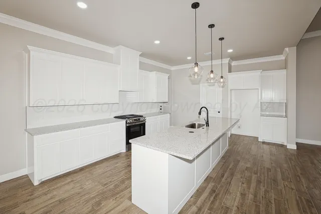 a open kitchen with a sink dishwasher a stove and a refrigerator with wooden floor