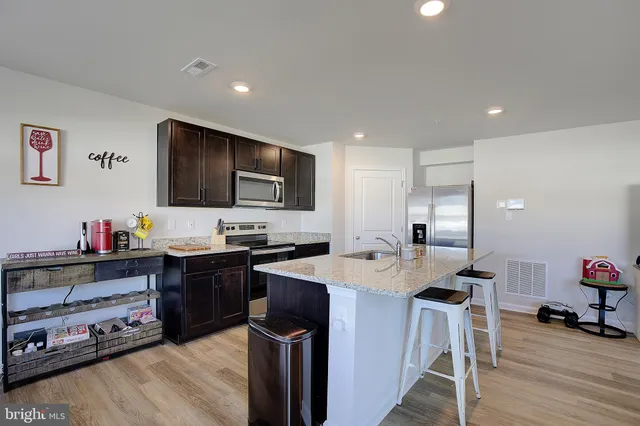 a kitchen with granite countertop a counter top space and wooden floor