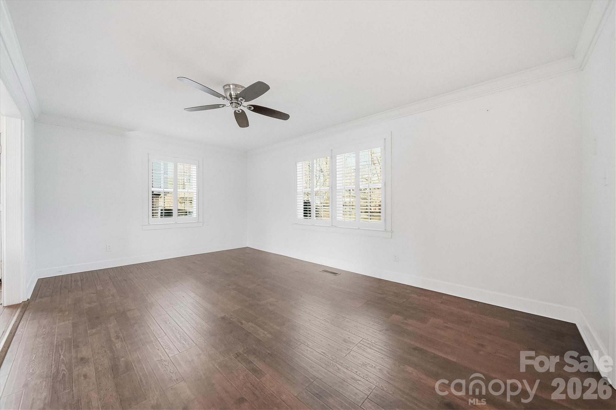 1215 6th Street Northwest Hickory, NC 28601 - Photo 12 of 48 an empty room with wooden floor ceiling fan and windows