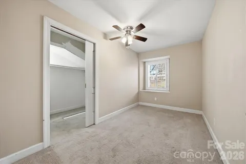 an empty room with windows and fireplace