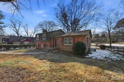 a front view of a house with a yard covered with snow in front of house