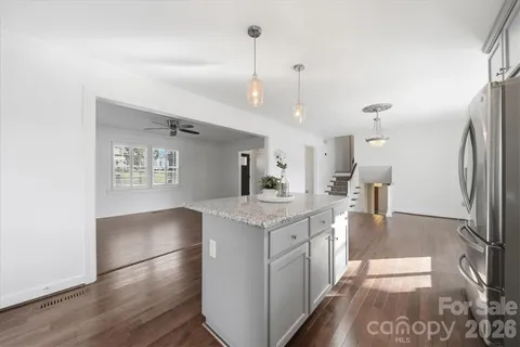 a kitchen with stainless steel appliances granite countertop a stove a sink dishwasher a refrigerator and a microwave