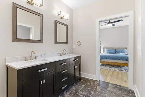 a en suite bathroom with a double vanity sink and a mirror