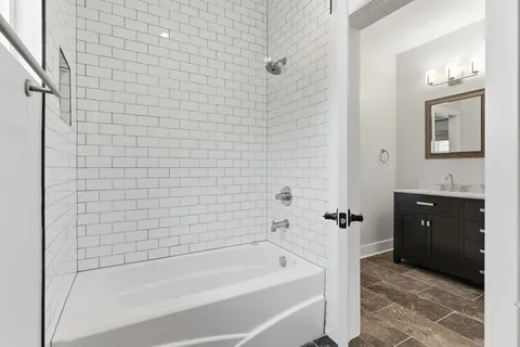 a bathroom with a tub shower sink and mirror