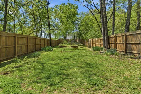 a backyard of a house with lots of plants and tree