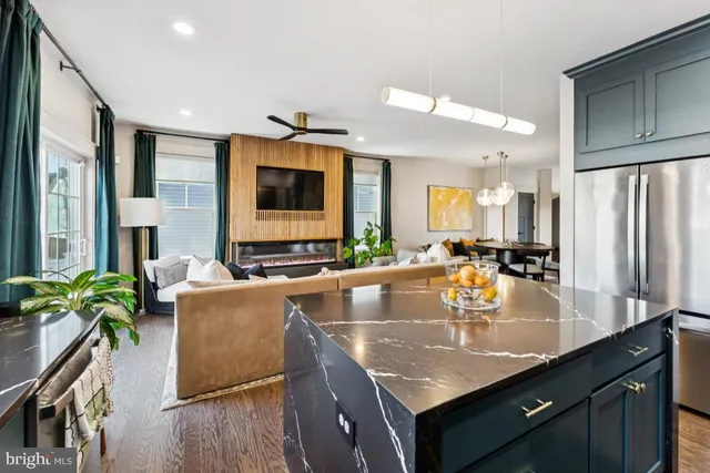 a kitchen with granite countertop a sink a counter top space and living room area