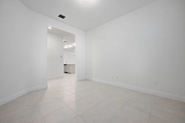 a view of kitchen with kitchen island white cabinets and refrigerator