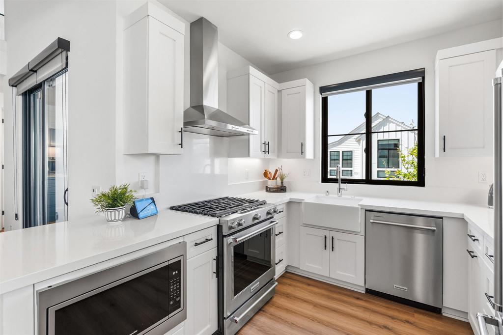 1602 San Remo Place, Unit 201 Encinitas, CA 92024 - Photo 15 of 56 a kitchen with stainless steel appliances white cabinets and a stove
