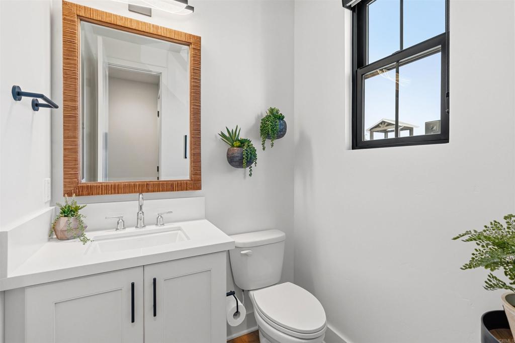 1602 San Remo Place, Unit 201 Encinitas, CA 92024 - Photo 20 of 56 a bathroom with a toilet sink and mirror