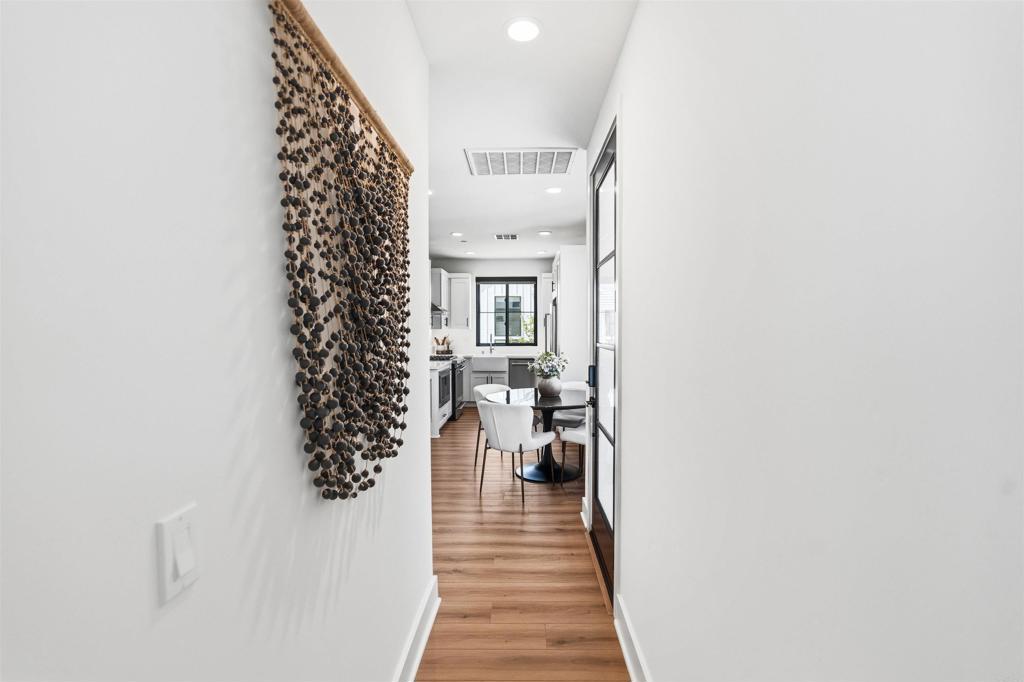1602 San Remo Place, Unit 201 Encinitas, CA 92024 - Photo 22 of 56 a view of a hallway with wooden floor and a potted plant
