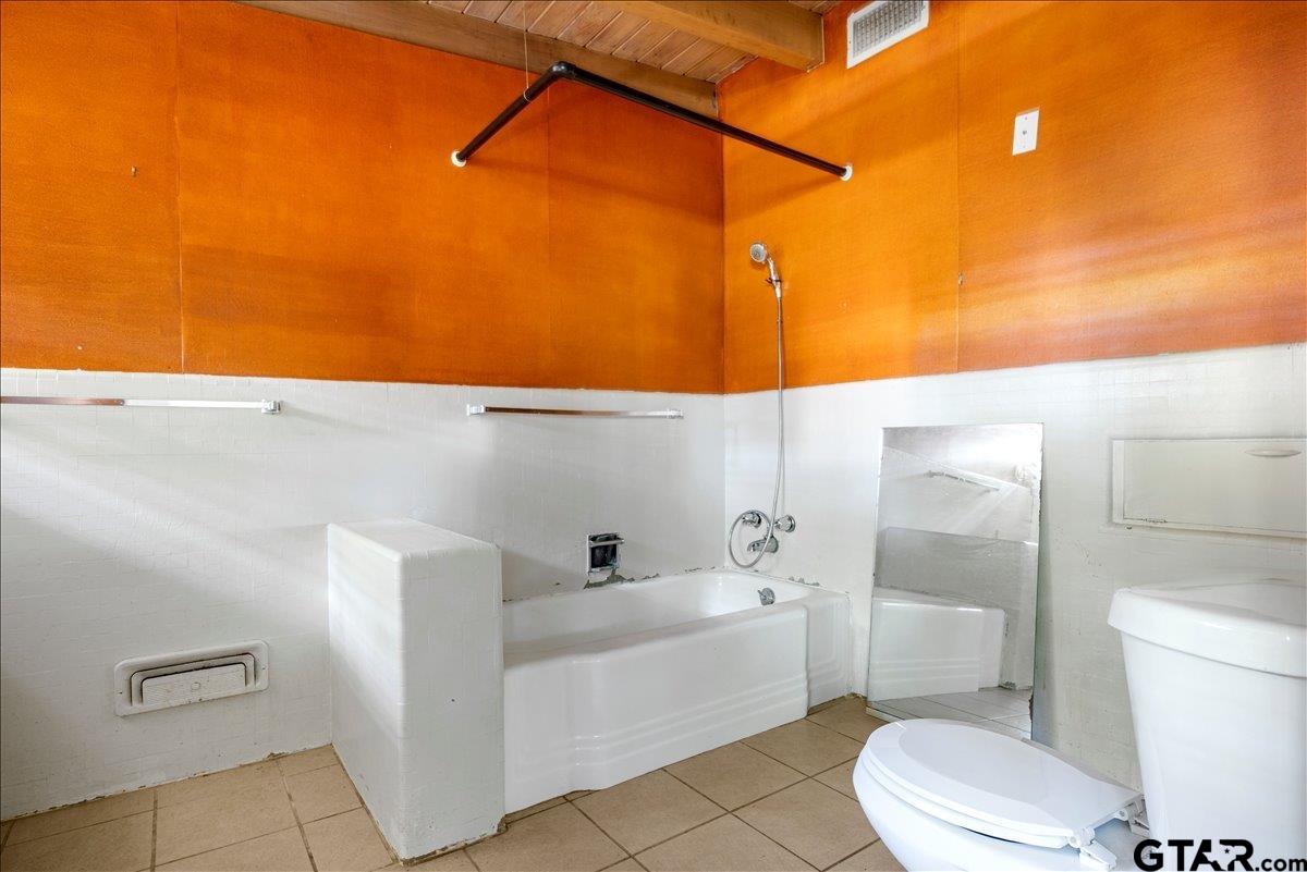 904 East Dulse Street Tyler, TX 75701 - Photo 16 of 27 a bathroom with a bathtub and a toilet