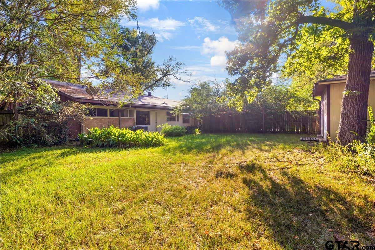 904 East Dulse Street Tyler, TX 75701 - Photo 23 of 27 a view of a house with a large tree and a yard