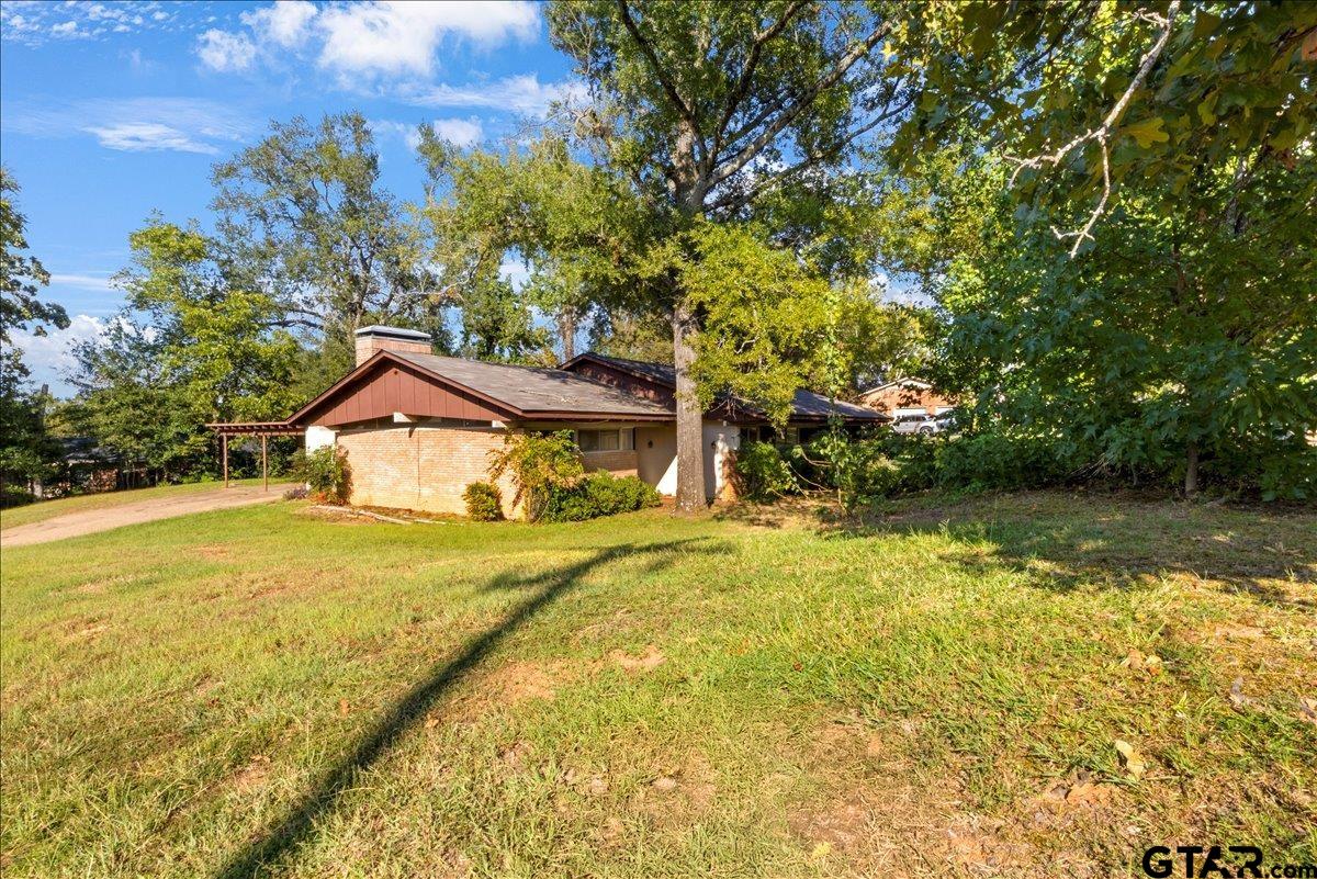 904 East Dulse Street Tyler, TX 75701 - Photo 3 of 27 a front view of a house with a yard and trees
