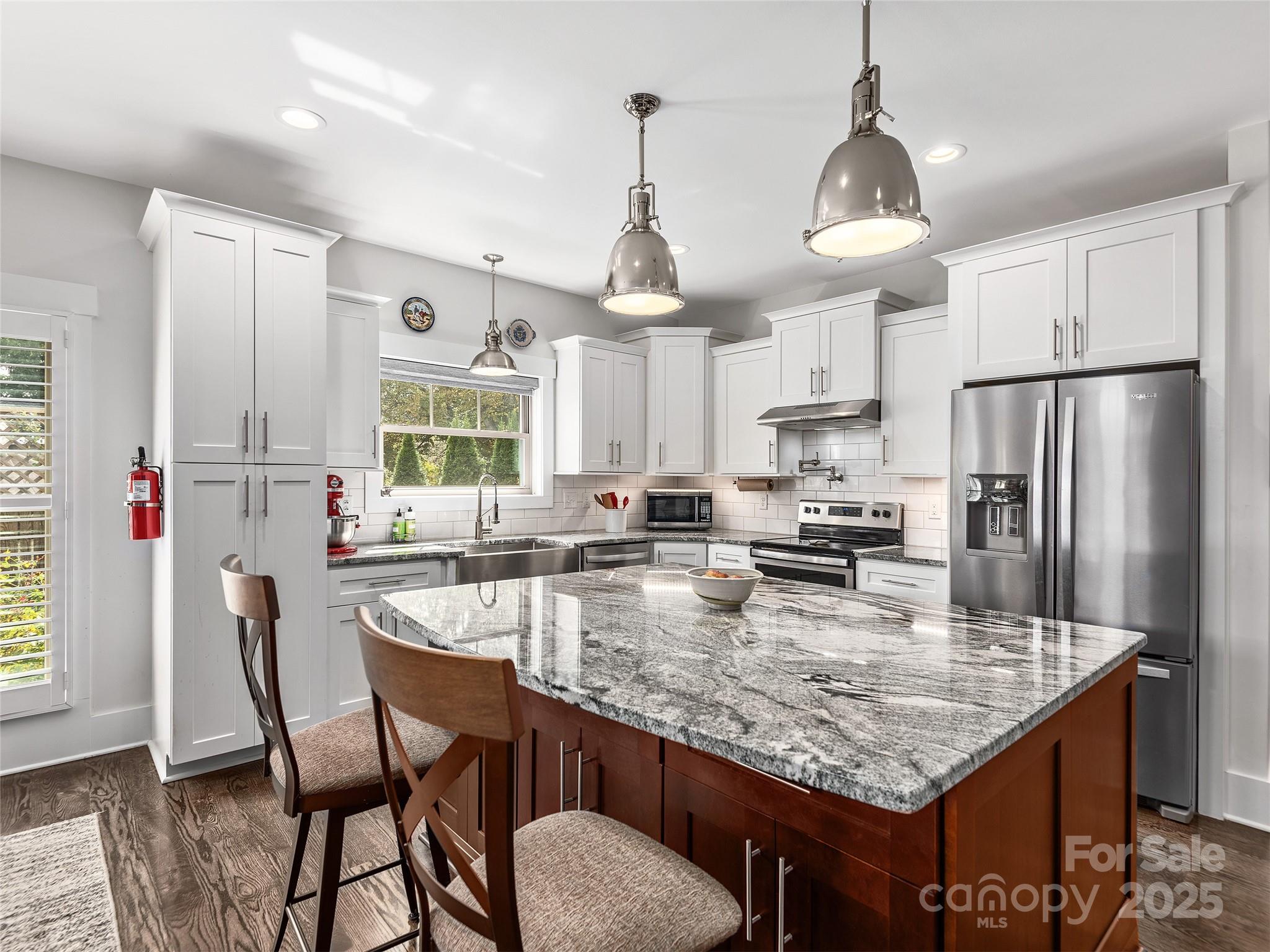 108 Enthoffer Road Black Mountain, NC 28711 - Photo 8 of 31 a kitchen with granite countertop kitchen island stainless steel appliances a table chairs sink refrigerator and microwave