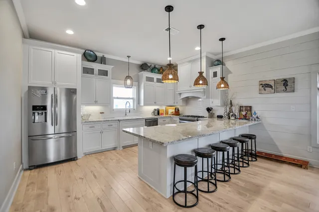 a kitchen with stainless steel appliances granite countertop a sink a stove and a refrigerator