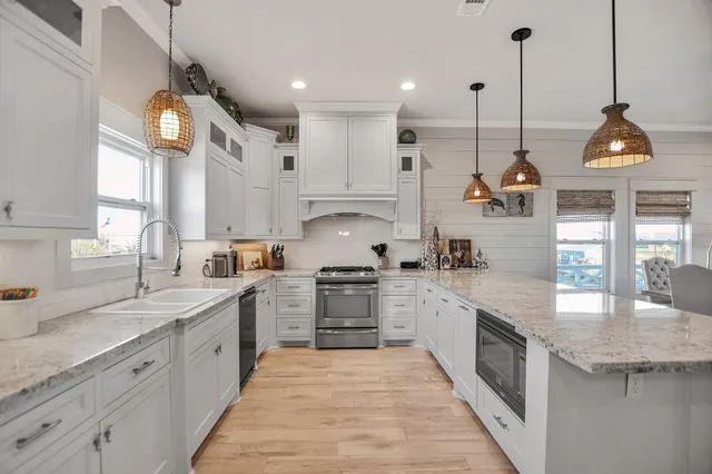 a kitchen with white cabinets appliances and a sink