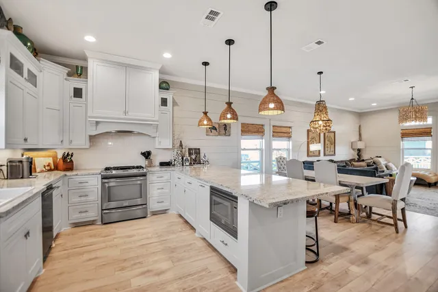 a kitchen with stainless steel appliances kitchen island granite countertop a stove a sink and a refrigerator