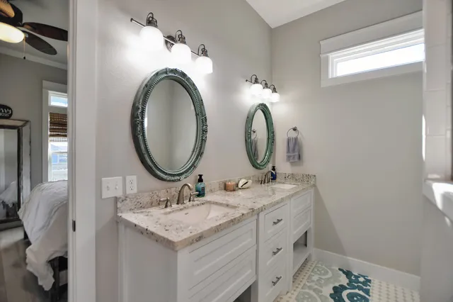 a bathroom with a granite countertop double vanity sink and a mirror