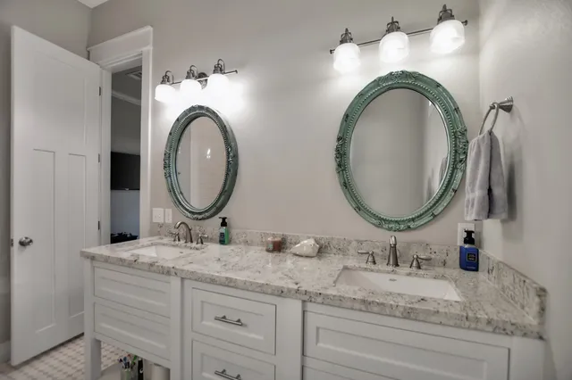 a bathroom with a granite countertop double vanity sinks and a mirror