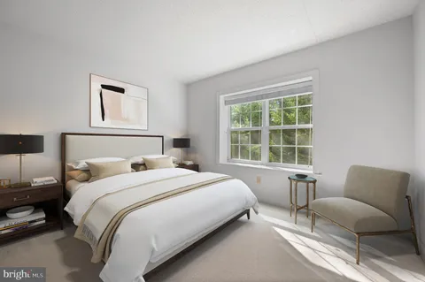 a bedroom with a bed and a couch with window