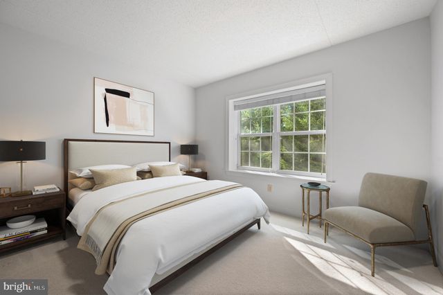 a bedroom with a bed and a couch with window