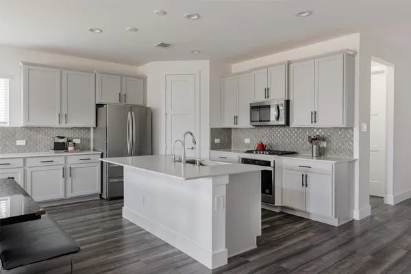 a kitchen with white cabinets and stainless steel appliances