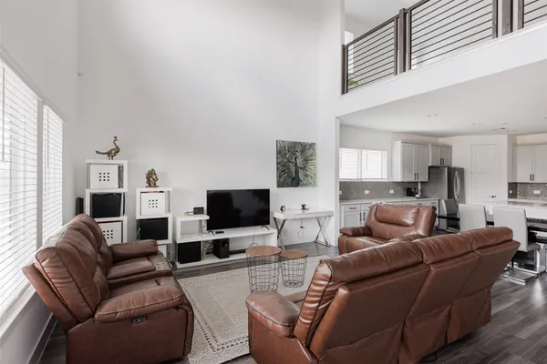 a living room with furniture a flat screen tv and wooden floor