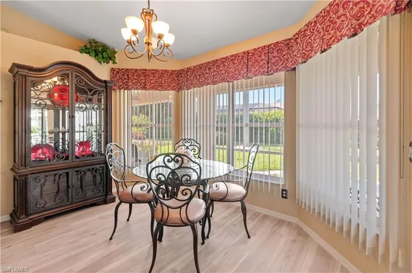 a view of a dining room with furniture a chandelier and wooden floor