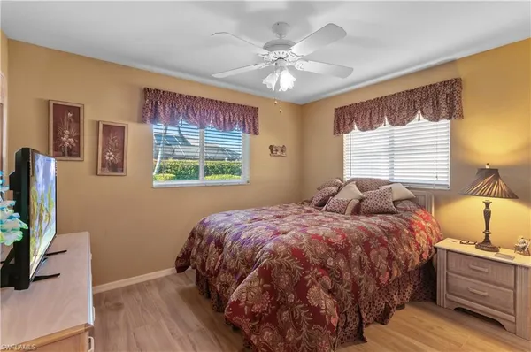 a bedroom with a bed and a flat tv screen on the dresser