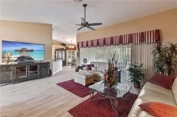 a living room with furniture kitchen view and a large window