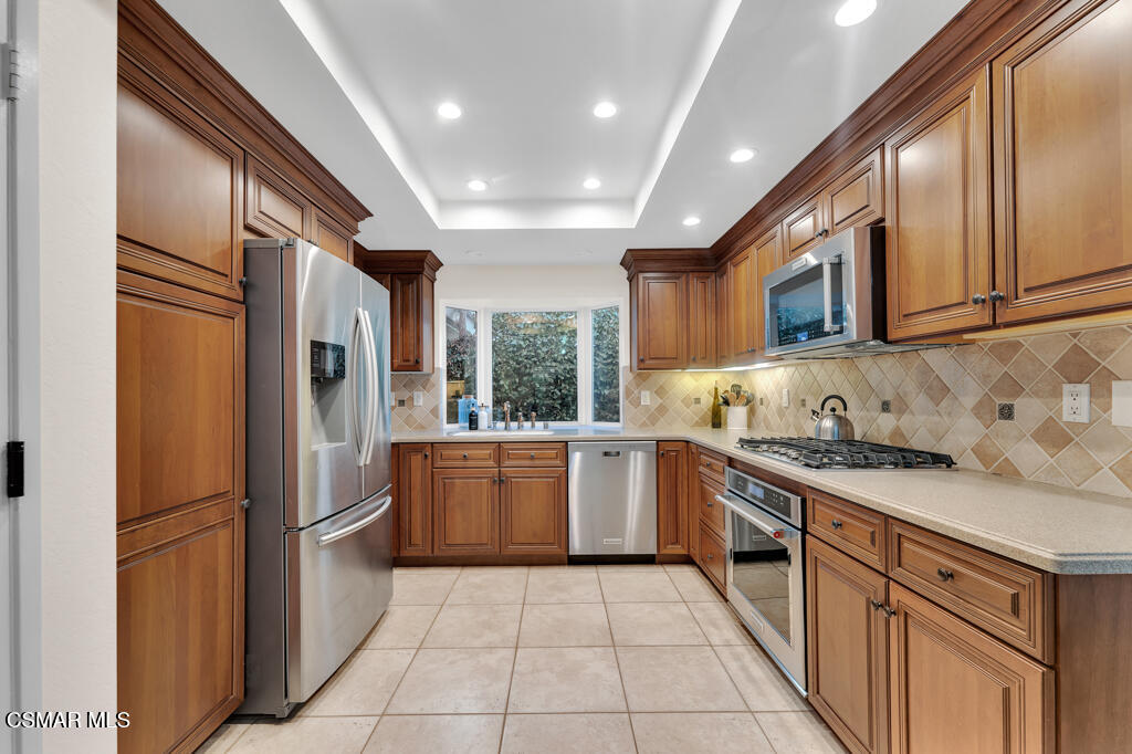 16 Valley Crest Road Simi Valley, CA 93065 - Photo 12 of 41 a large kitchen with stainless steel appliances granite countertop a refrigerator a sink dishwasher a stove and white cabinets with wooden floor