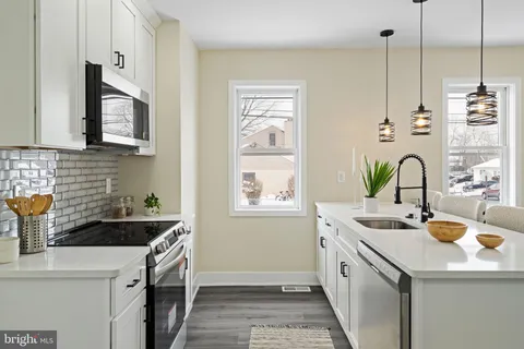 a kitchen that has a sink and a stove in it
