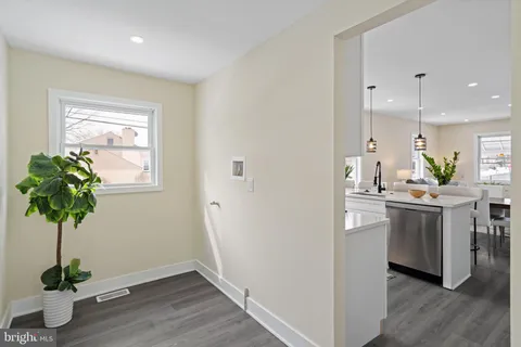 a kitchen with white cabinets and wooden floor