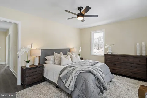 a spacious bedroom with a bed a window and a dresser