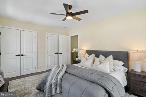a bedroom with a bed and a ceiling fan