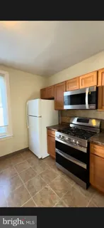 a kitchen with stainless steel appliances a stove a microwave and white cabinets