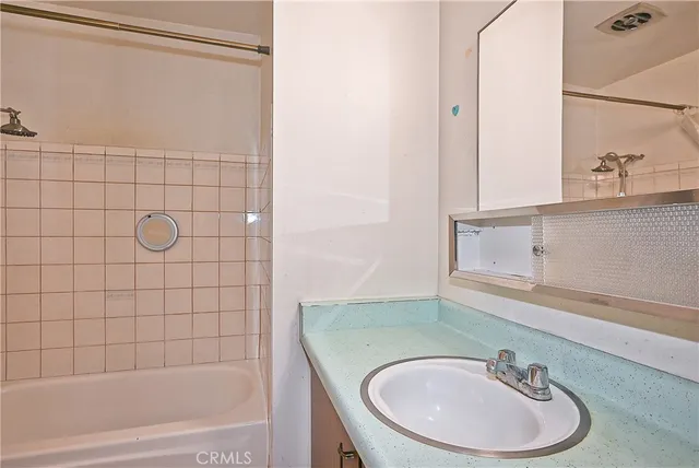 a bathroom with a sink a mirror and a bathtub