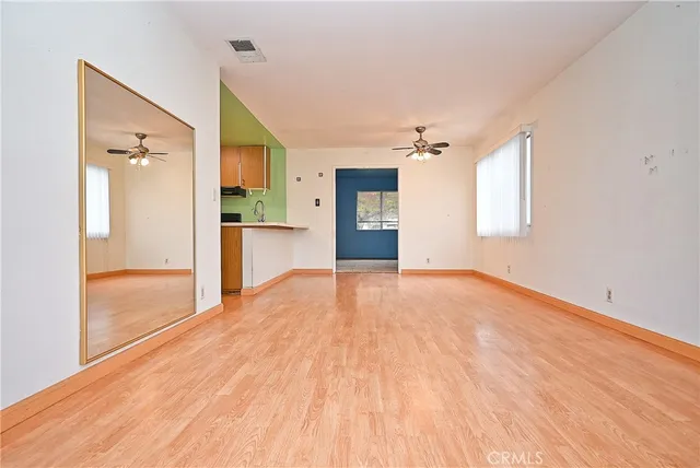 a view of a big room with wooden floor and windows