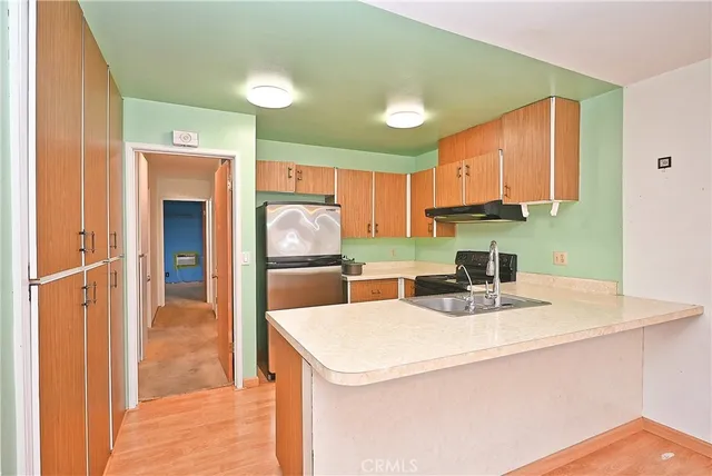 a kitchen with refrigerator and cabinets