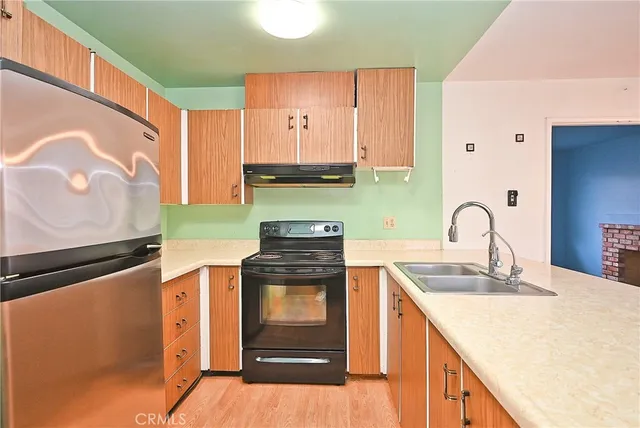 a kitchen with stainless steel appliances granite countertop a stove a sink and a microwave