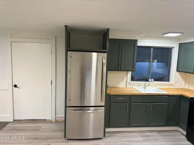 a kitchen with stainless steel appliances granite countertop a refrigerator and a sink