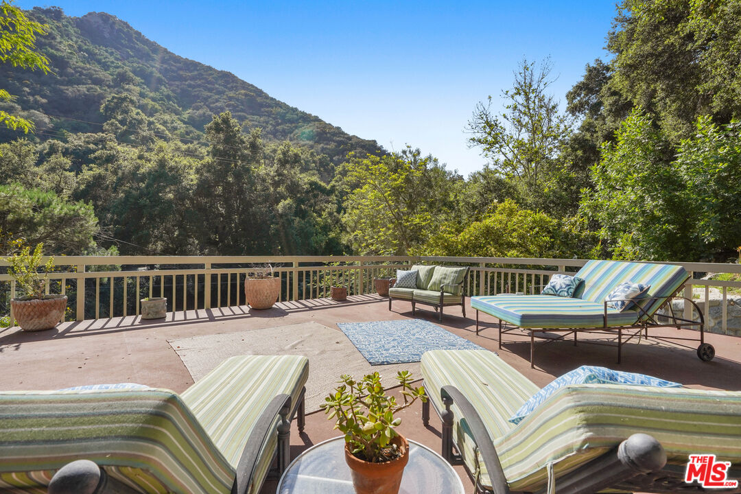 964 Old Topanga Canyon Road Topanga, CA 90290 - Photo 3 of 75 a view of a balcony with chairs and wooden floor