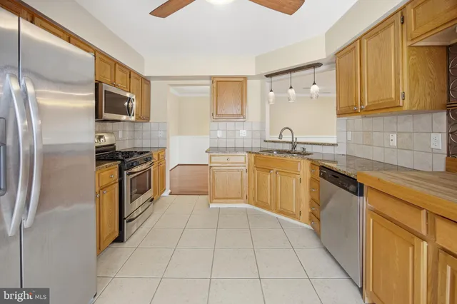 a kitchen with stainless steel appliances granite countertop a refrigerator sink and cabinets