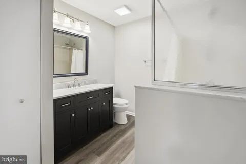 a bathroom with a double vanity sink and mirror with toilet