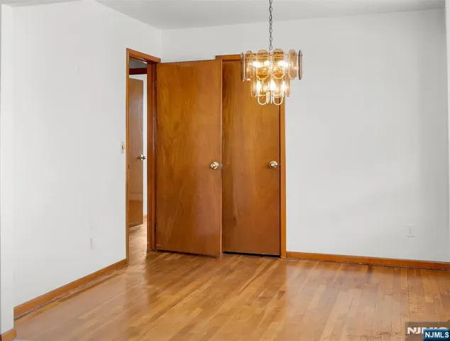 a spacious bedroom with a bed and wooden floor