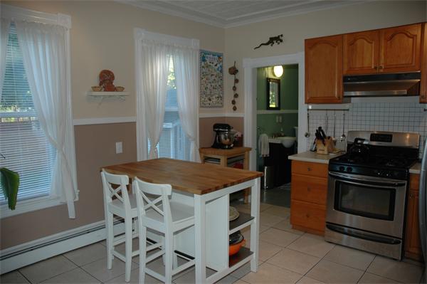126 Mammoth Road Lowell, MA 01854 - Photo 6 of 23 a kitchen with a stove a sink and a refrigerator