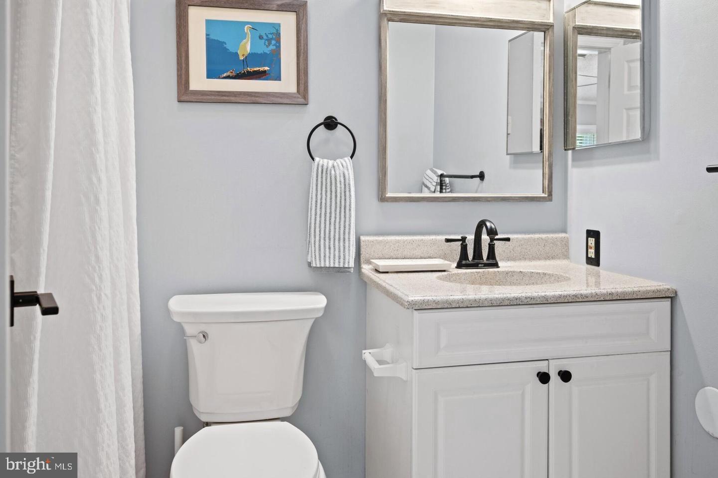 32217 Sandpiper Drive Lewes, DE 19958 - Photo 12 of 21 a bathroom with a toilet sink and mirror
